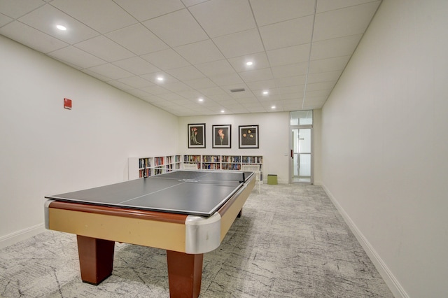 recreation room with a drop ceiling and light colored carpet