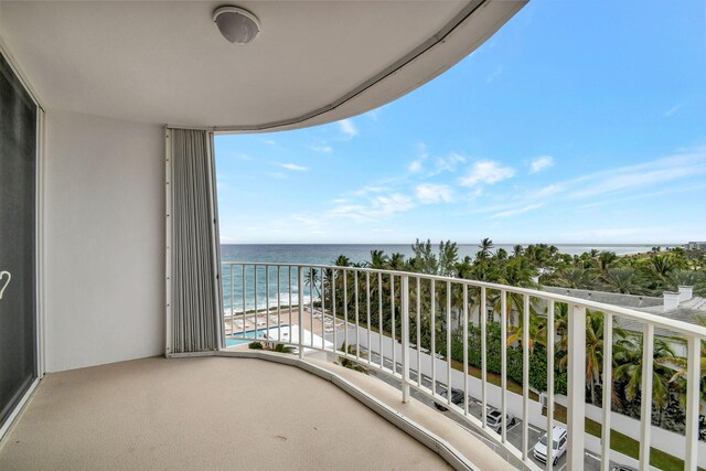 balcony featuring a water view and a beach view