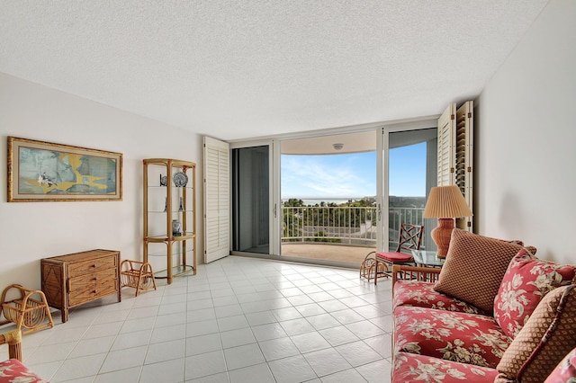 tiled living room featuring a textured ceiling and a wall of windows