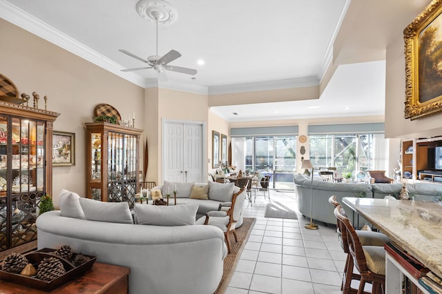 tiled living room featuring ceiling fan and ornamental molding