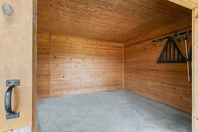 empty room with wood walls, carpet floors, and wood ceiling