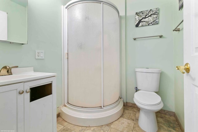 bathroom featuring vanity, toilet, and an enclosed shower