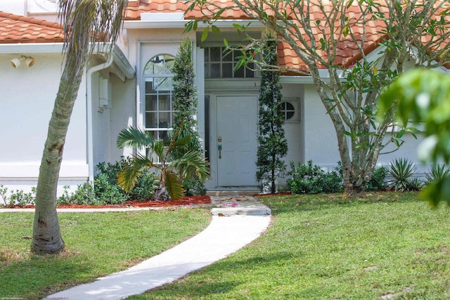 doorway to property featuring a lawn