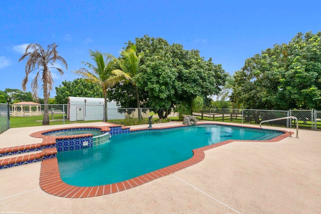 view of pool featuring a patio area and an in ground hot tub