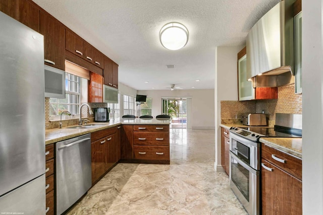 kitchen featuring kitchen peninsula, a wealth of natural light, sink, and appliances with stainless steel finishes