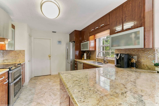 kitchen featuring sink, kitchen peninsula, stainless steel appliances, and tasteful backsplash