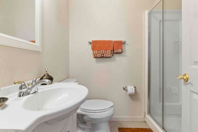 bathroom featuring tile patterned floors, a shower with door, vanity, and toilet