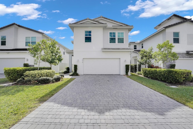 front facade featuring a garage and a front lawn