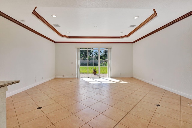 unfurnished room featuring light tile patterned floors, a raised ceiling, and ornamental molding