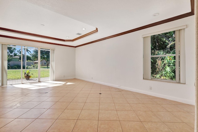 empty room featuring a raised ceiling, light tile patterned floors, and ornamental molding