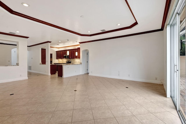 unfurnished living room with a raised ceiling, light tile patterned floors, and ornamental molding