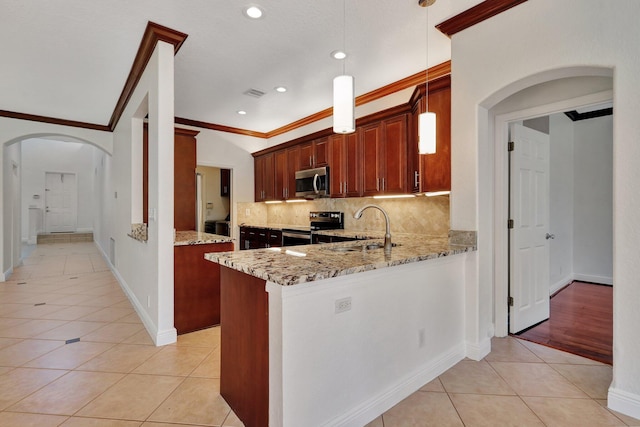 kitchen featuring sink, hanging light fixtures, kitchen peninsula, appliances with stainless steel finishes, and ornamental molding