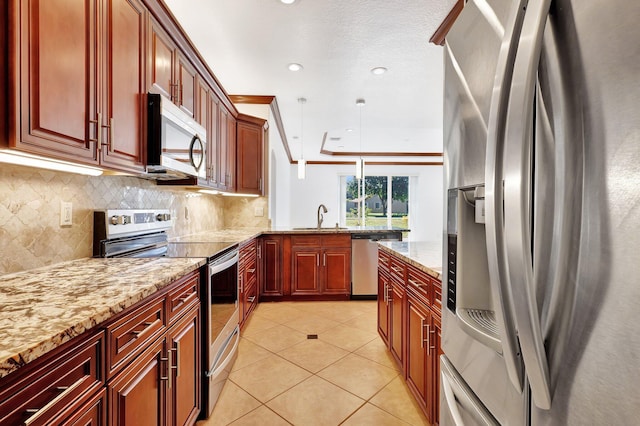 kitchen with pendant lighting, a textured ceiling, appliances with stainless steel finishes, tasteful backsplash, and light tile patterned flooring