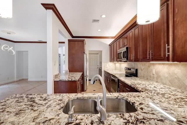 kitchen with sink, decorative backsplash, light stone countertops, ornamental molding, and stainless steel appliances