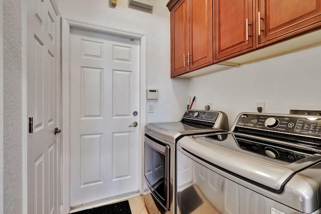 laundry room with cabinets, independent washer and dryer, and light tile patterned floors