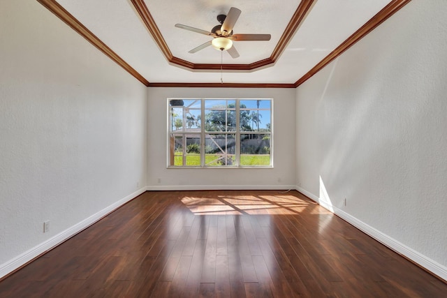 empty room featuring a raised ceiling, ceiling fan, hardwood / wood-style floors, and crown molding