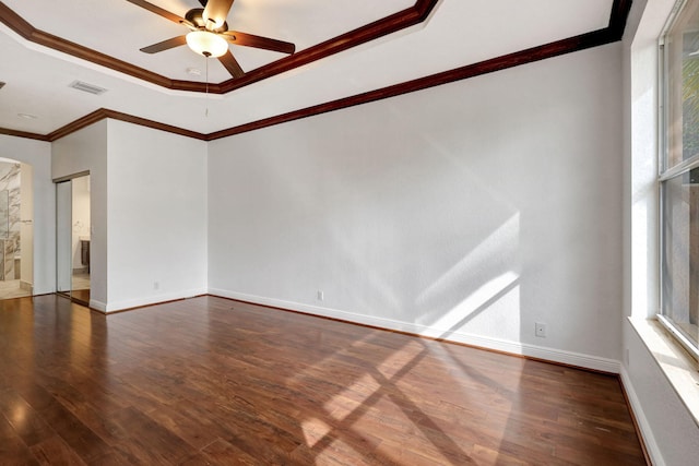 spare room with a raised ceiling, ceiling fan, dark hardwood / wood-style flooring, and crown molding