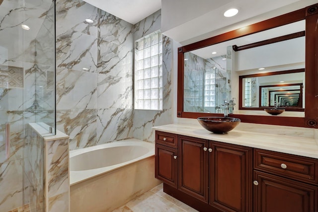 bathroom featuring separate shower and tub, vanity, and tile walls