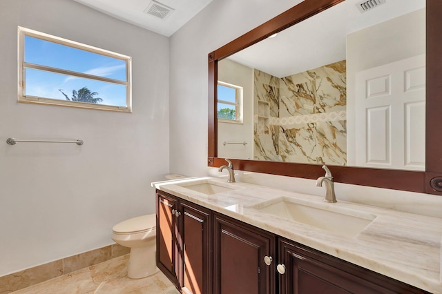 bathroom featuring tiled shower, vanity, and toilet