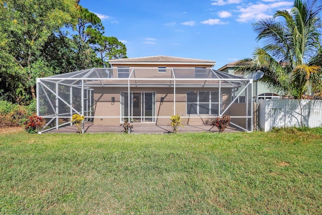 rear view of house featuring a lanai and a lawn