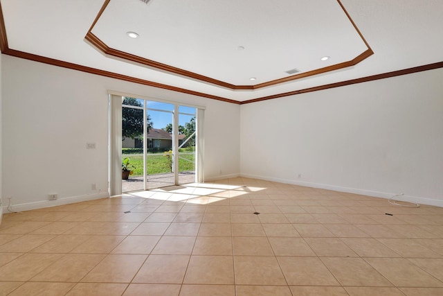 tiled empty room featuring a tray ceiling and ornamental molding