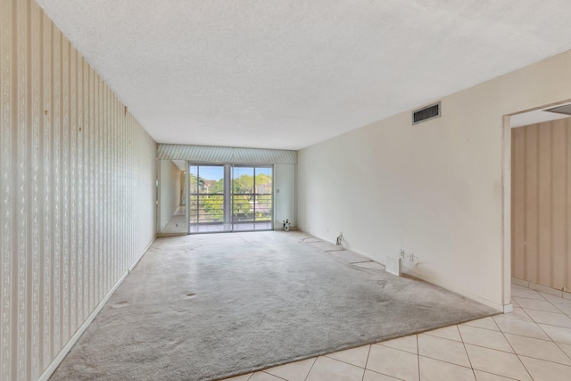 unfurnished room with light tile patterned floors and a textured ceiling