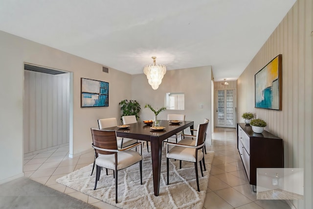 dining space with light tile patterned floors and a notable chandelier