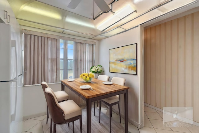 tiled dining space featuring ceiling fan