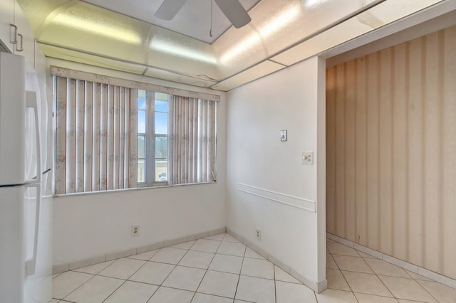 spare room featuring ceiling fan and light tile patterned flooring