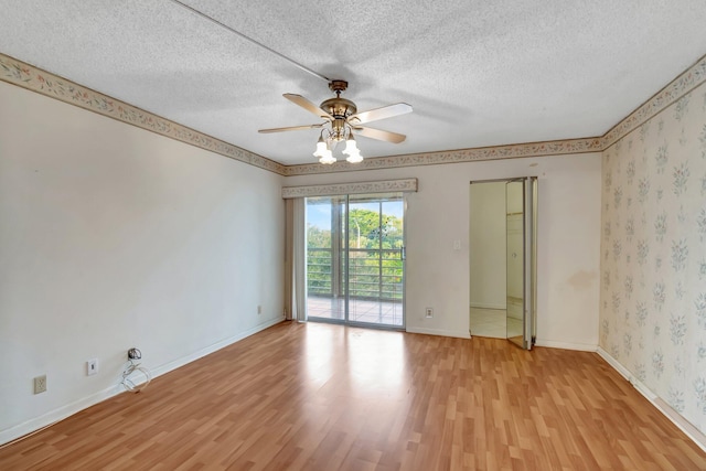 empty room featuring ceiling fan, light wood-type flooring, and a textured ceiling