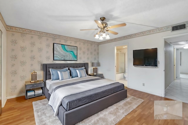 bedroom with hardwood / wood-style flooring, ceiling fan, and connected bathroom