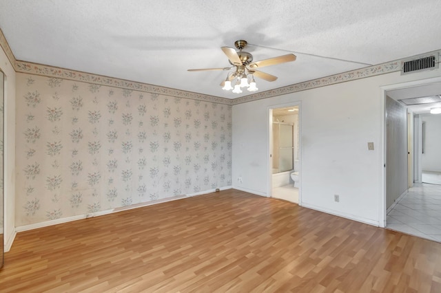 unfurnished room featuring a textured ceiling, light wood-type flooring, and ceiling fan