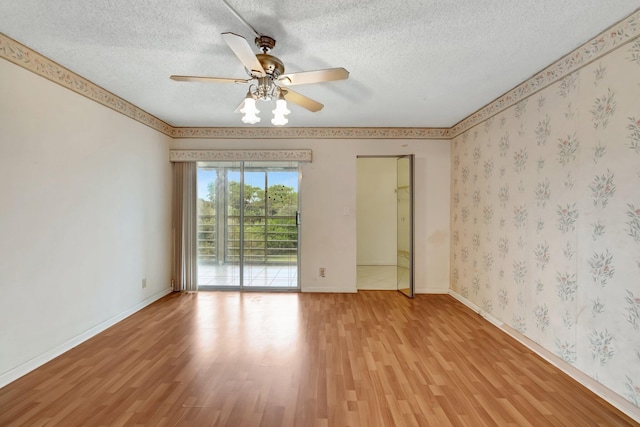 spare room with ceiling fan, light hardwood / wood-style floors, and a textured ceiling