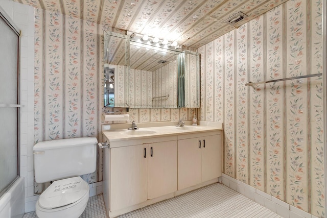 full bathroom with tile patterned floors, vanity, combined bath / shower with glass door, and toilet