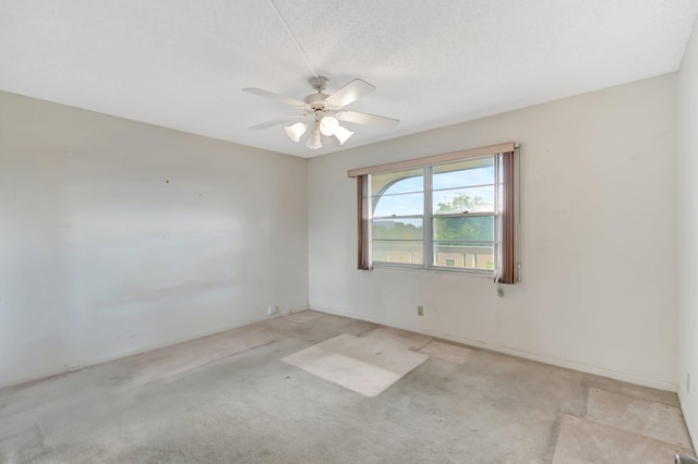 carpeted spare room with a textured ceiling and ceiling fan