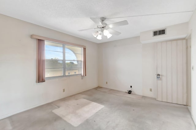 carpeted spare room featuring a textured ceiling and ceiling fan