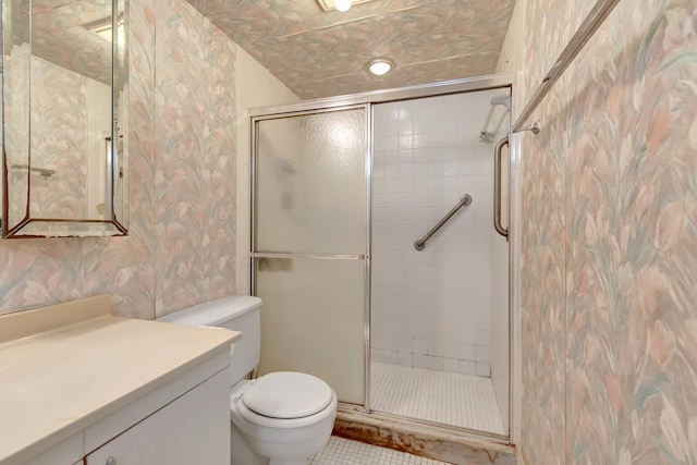 bathroom featuring tile patterned floors, vanity, a shower with shower door, and toilet