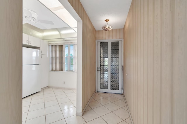 doorway to outside featuring ceiling fan and light tile patterned flooring