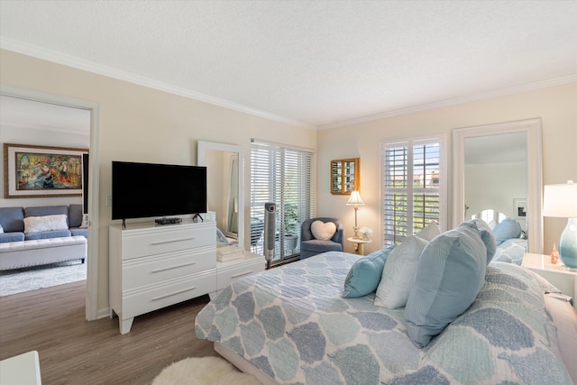 bedroom featuring ornamental molding, a textured ceiling, access to outside, and dark wood-type flooring