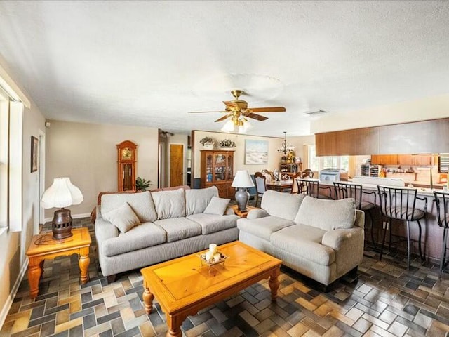 living room with a textured ceiling and ceiling fan