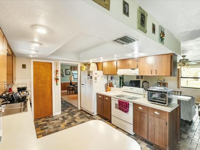 kitchen with ceiling fan, sink, white appliances, and a textured ceiling