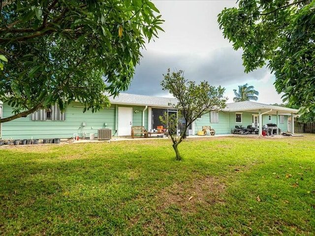 view of front of home with cooling unit and a front lawn