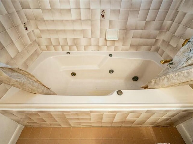 bathroom featuring tile patterned flooring and a relaxing tiled tub