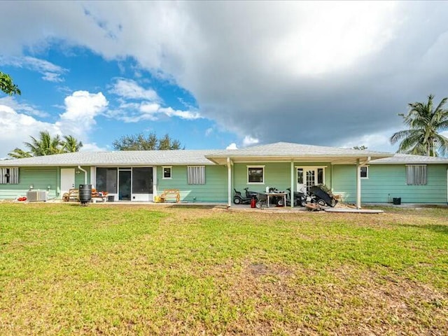 rear view of property featuring cooling unit and a yard