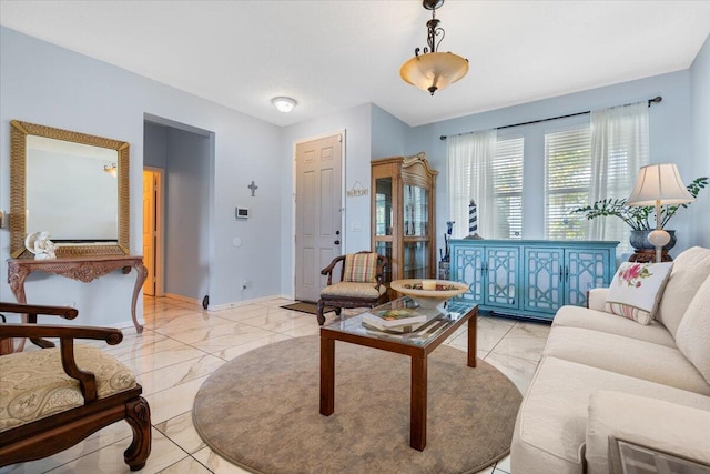 living area featuring marble finish floor and baseboards