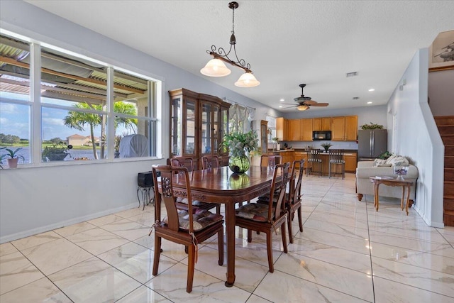 dining area with visible vents, baseboards, marble finish floor, a textured ceiling, and a ceiling fan