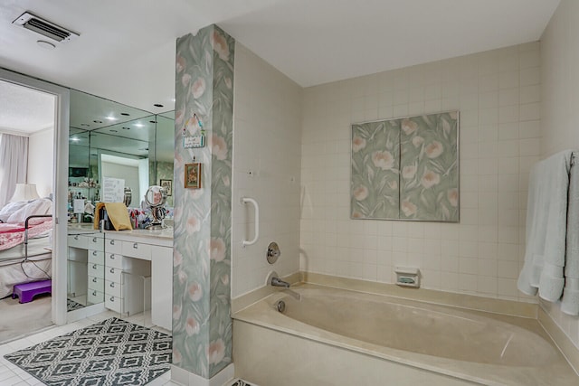 bathroom with a bathing tub, tile patterned flooring, and vanity