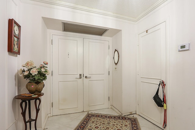 foyer entrance featuring a textured ceiling and ornamental molding