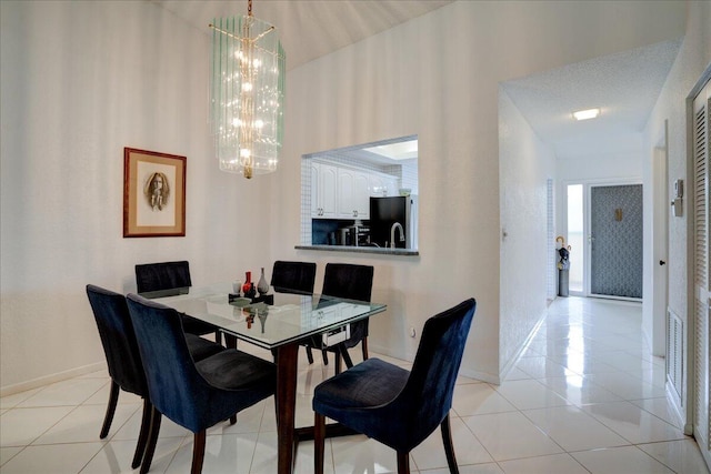 dining room featuring light tile patterned floors, a textured ceiling, and an inviting chandelier