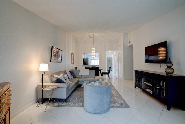 living room with light tile patterned floors and an inviting chandelier